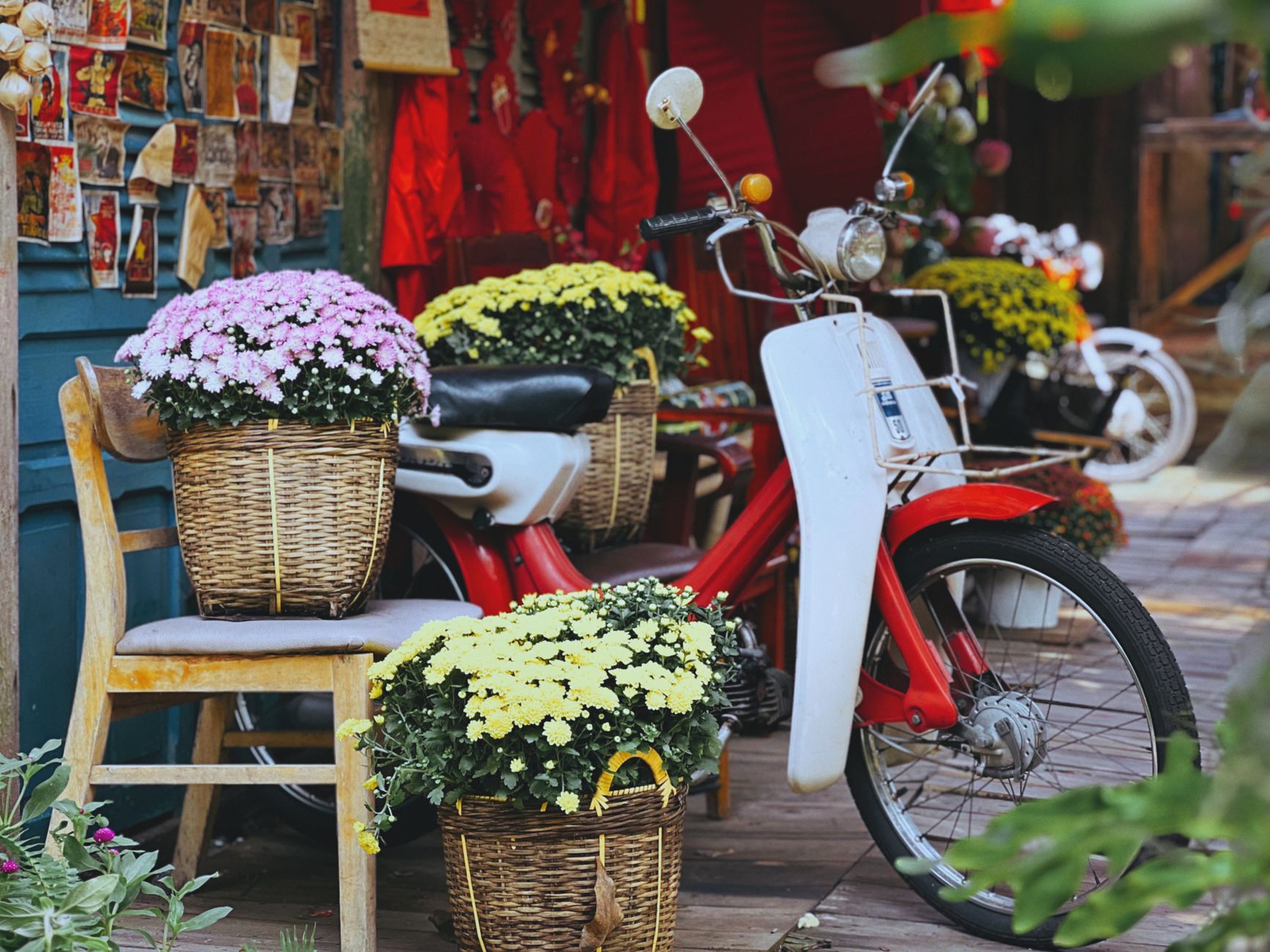 Baskets of colorful potted flowers displayed at a small outdoor market stall